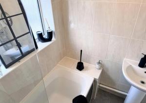 a white bathroom with a sink and a bath tub at Luxurious Retreat 4bd in Maidstone in Kent