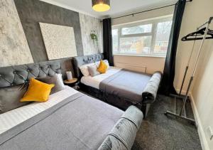 a bedroom with two beds with yellow pillows at Luxurious Retreat 4bd in Maidstone in Kent