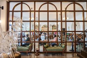 a room with large windows and people sitting in a restaurant at Hotel Emeline in Charleston