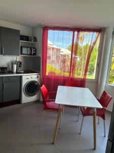 a kitchen with a table and chairs and a window at les perles de gosier in Le Gosier +8 photos