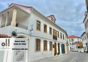 un edificio blanco con un cartel en una calle en OH Studios Lousã, en Lousã