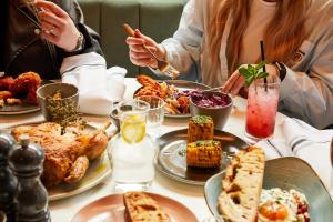 a group of people sitting at a table with food at Hotel Indigo Newcastle by IHG in Newcastle upon Tyne