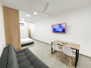 una sala de estar con un sofá y una mesa en Loft del Río Honda - Apartaestudio completo con parqueadero y aire acondicionado, en Honda