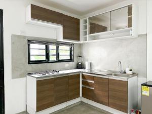 a kitchen with wooden cabinets and a sink and a window at Loft del Río - Apartaestudio Completo - Aire Acondicionado, Parqueadero, WiFi, Pet Friendly in Honda