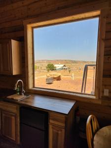 a window in a kitchen with a view of a field at The Rocky Mountain Cabin in Apple Valley