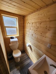 a wooden bathroom with a toilet and a sink at The Rocky Mountain Cabin in Apple Valley