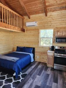 a bedroom with a bed in a wooden cabin at The Rocky Mountain Cabin in Apple Valley