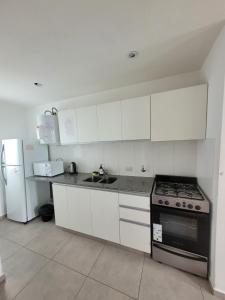 a kitchen with white cabinets and a stove and refrigerator at Depto Zona Plaza Paso con opcion de Cochera byLofter in La Plata +15 photos