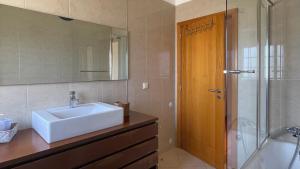 een badkamer met wastafel en douche met spiegel bij Cantinho do Minho - Ponte de Lima in Ponte de Lima