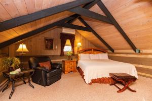 a bedroom with a bed and a chair in a room at Azalea Garden Inn in Blowing Rock
