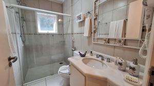 a bathroom with a sink and a shower and a toilet at Pousada Atalaia Premium in Campos do Jordão +36 photos