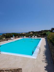 a swimming pool with blue water and a view of the ocean at La Finestra su Stintino in Stintino
