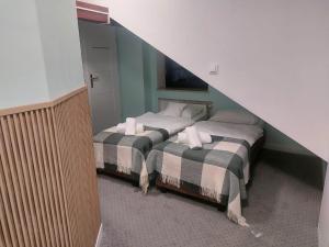two twin beds in a room with at Browar Gościniec Chojnice in Chojnice