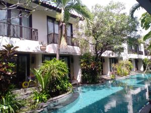 a hotel with a swimming pool in front of a building at Seminyak Apartment by LBV in Seminyak