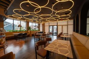 un restaurante con una gran lámpara de araña dorada en Aiden by Best Western Georgetown Guyana, en Georgetown