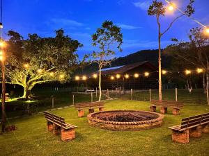 a park with benches and a fire pit at night at Sítio Quinta do sossego in Indaial