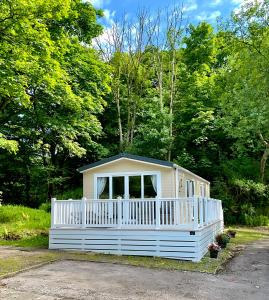 a small white house with a white fence at Ribble Heights Lodge - Cosy Pet-Free Countryside Retreat in Longridge