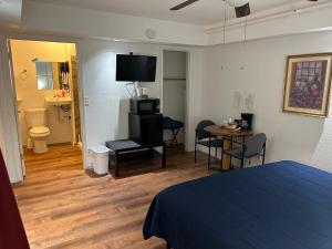 a room with a bed and a table and a television at K7 Bed and Breakfast in Pahrump