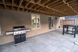 an outdoor patio with a stove and a table at Modern and Cozy Basement Stay in Ajax in Ajax