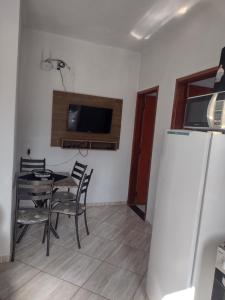 a dining room with a table and chairs and a tv at Apartamento avenida 06 com ar condicionado in São Thomé das Letras +9 photos