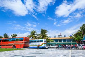 two buses parked in a parking lot in front of a building at 蘋果樹民宿 - 花蓮火車站住宿有電梯附停車場 in Hualien City