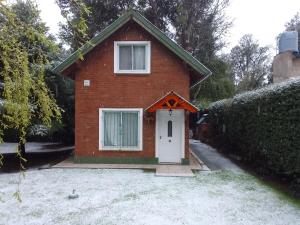 a small red brick house with a white door at Cabañas flotter in Villa Ventana