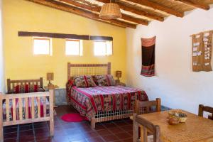 a bedroom with a bed and a table in a room at Hosteria La Morada in Tilcara +146 photos