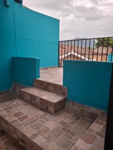 a balcony with a blue wall and some stairs at Hostal Primaveras nest habitación 3 in Santa Ana
