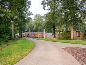 a road with trees and a building in the distance at Waterside Luxury Escape in Antoing