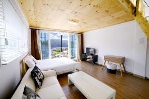 a room with a bed and a couch and a table at Walking Sky Pension in Gapyeong
