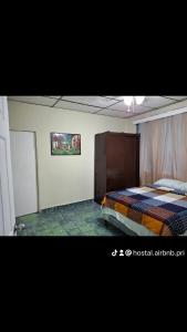 Un dormitorio con una cama y un cuadro en la pared. en Hostal primaveras nest, en Santa Ana