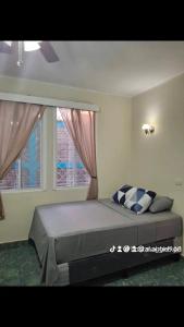 Un dormitorio con una cama grande con dos ventanas. en Hostal primaveras nest, en Santa Ana