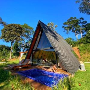 a woman laying in a swimming pool in a triangular house at Refúgio dos Alpes cabana in Teresópolis
