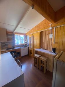 a large kitchen with wooden walls and wooden floors at Los Álamos in Puerto Tranquilo