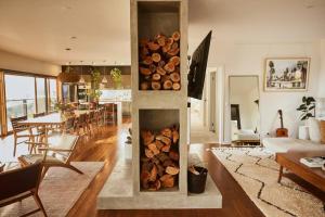 a living room with a stack of fire logs at The Good House in Kiewa