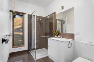 a bathroom with a white sink and a shower at The Good House in Kiewa +64 photos