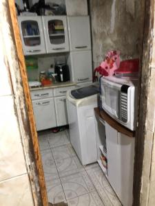 a kitchen with a microwave and a washer and dryer at TubacityHouse in Salvador