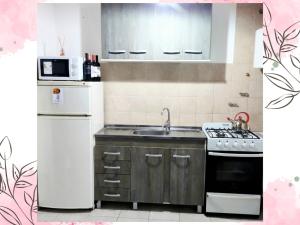 Una cocina con un refrigerador blanco y un fregadero. en Depto Cogli, en Ezeiza