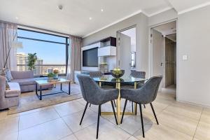a living room with a table and chairs and a couch at Masingita Towers Hotel, Luxurious Sunset Condo in Johannesburg
