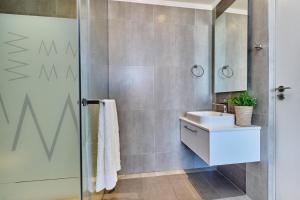 a bathroom with a sink and a shower at Masingita Towers Hotel, Luxurious Sunset Condo in Johannesburg