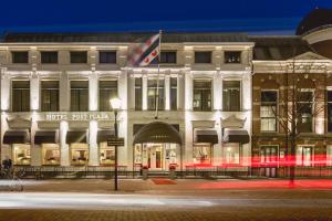 um edifício branco com uma bandeira na frente em Post-Plaza Hotel & Grand Café em Leeuwarden