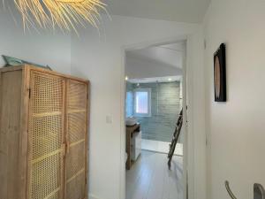 a bathroom with a wooden cabinet and a hallway at Villa rénovée avec accès plage, clim, WiFi, parking - FR-1-413-248 in Capbreton