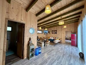 a living room with wooden walls and a wooden floor at Cabaña entre bosque y mar in Boyeruca