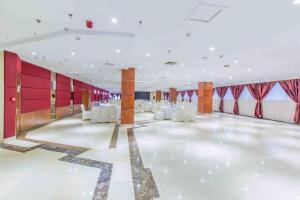 a large room with white chairs and red walls at Changchun Garden Hotel in Changchun