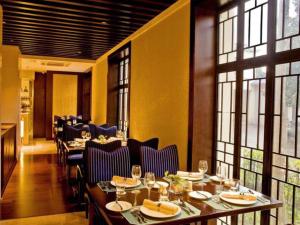 une salle à manger avec tables, chaises et fenêtres dans l'établissement Jin Jiang Nanjing Hotel, à Nankin