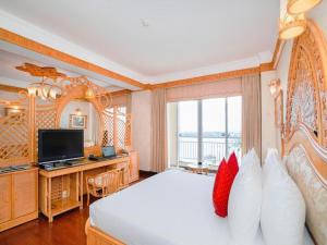 a bedroom with a bed and a desk and a television at Senriver Hotel in Danang