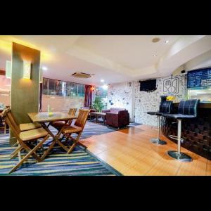 ein Wohnzimmer mit einem Tisch und einem Klavier in der Unterkunft Hotel Marlin Pekalongan Managed by Dafam in Waru Lor