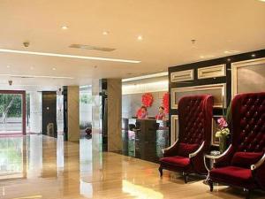a lobby with two red chairs and a bar at Downtown Hotel in Zhuhai