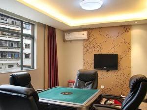 a room with a ping pong table and a tv at Downtown Hotel in Zhuhai