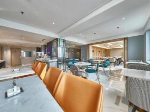 a dining room with chairs and tables in a building at Magnotel Business Shanghai Minhang Wujing East China Normal University in Shanghai
